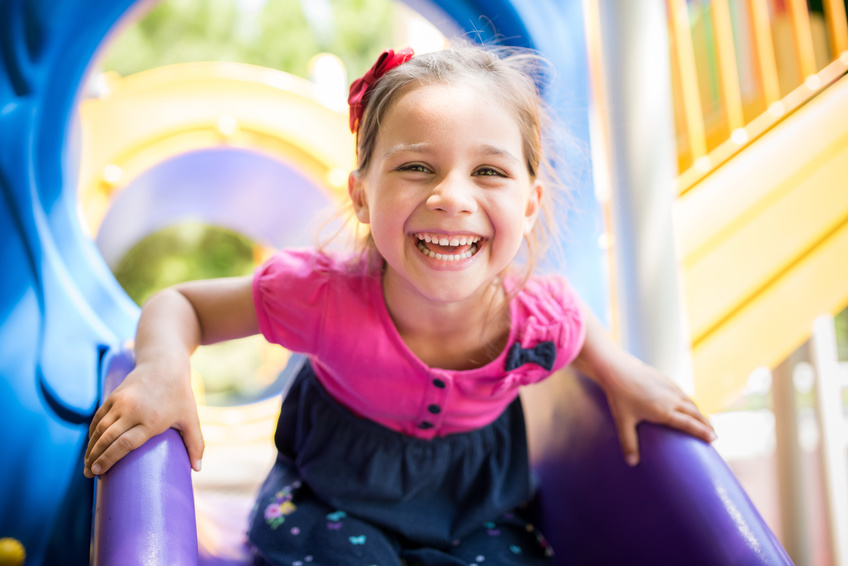 girl playing on purple slide in church indoor playground