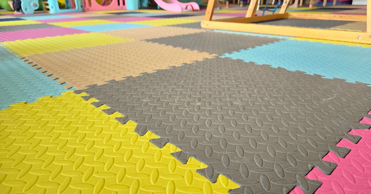 Foam mats in various colors, such as pink, gray, yellow, and blue, and in the shapes of interlocked puzzle pieces.