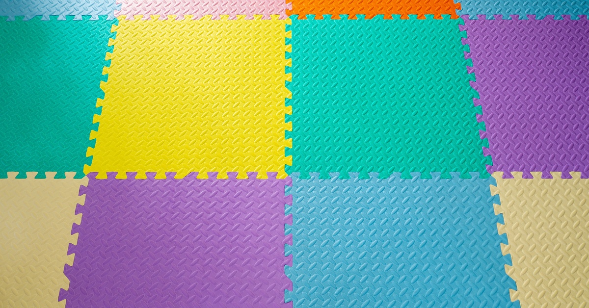 An overhead view of a foam tile floor with multiple colors such as green, light blue, yellow, purple, orange, and pink.
